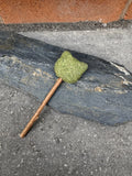 Catnip Lollipop Cat Toy with a cat-head shaped catnip top on a slate slab