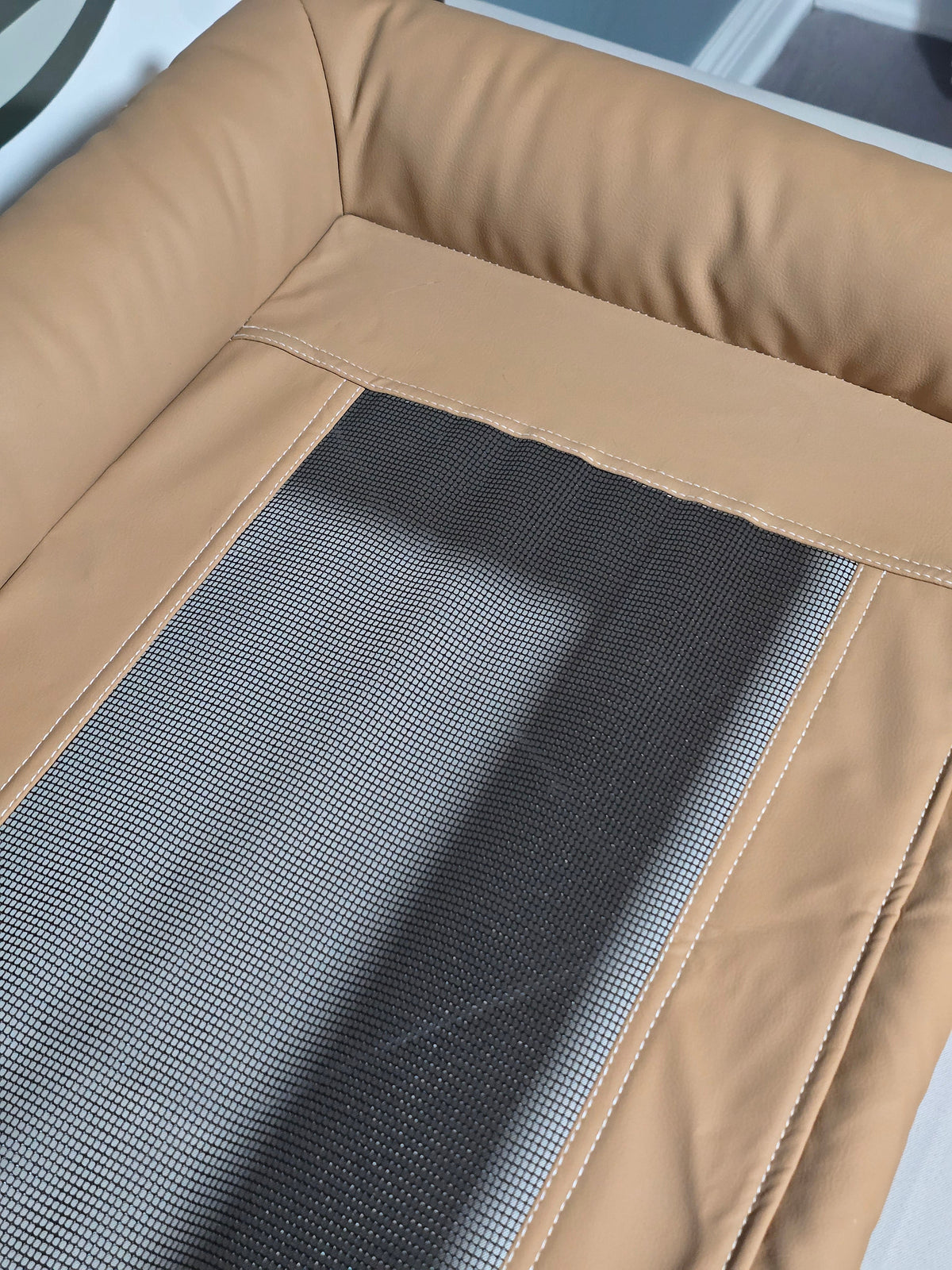 Top-down detail of the breathable mesh sleeping surface with contrast stitching