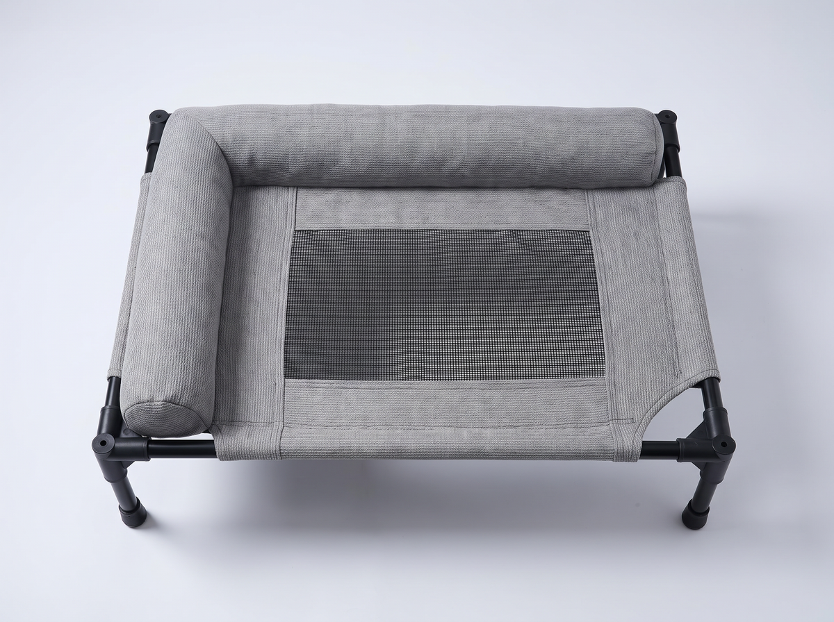 Top view of the grey Breeze Cot — L-shaped bolster and mesh centre